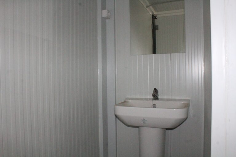 Lavabo con espejo en el aseo de un módulo prefabricado